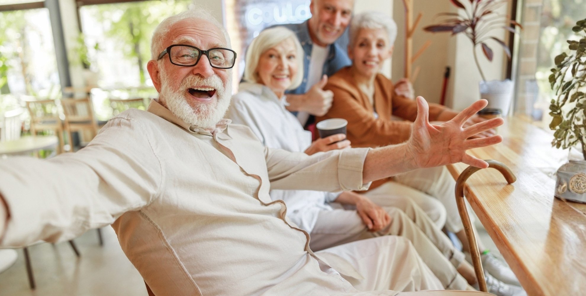 Senior man sitting and smiling with friends